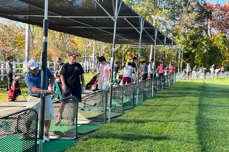 Golfers at the driving range hitting stations